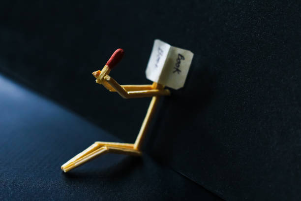 istock Matchstick concept and ideas. Book reading concept and ideas. Matchstick reading a book with black background. 1327621854