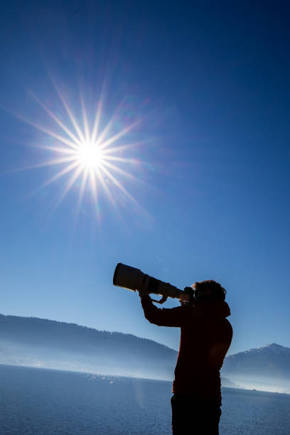 istock Young man taking photos outdoor with his digital camera 1327621957