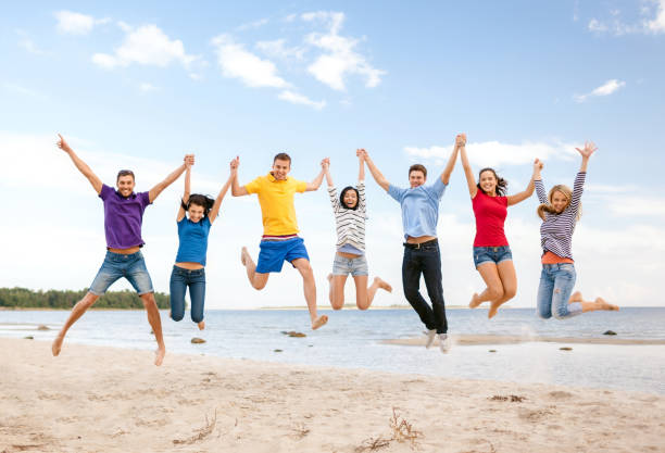 istock group of friends jumping on the beach 1327623734