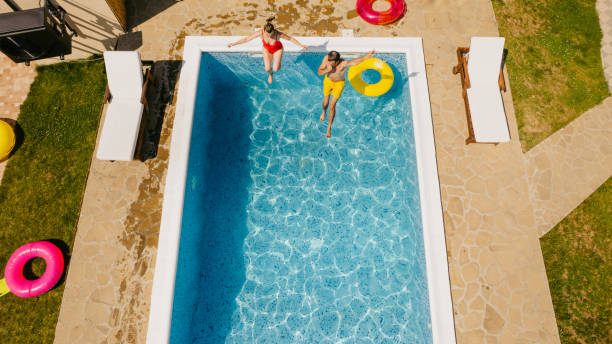 istock Couple jumping into the swimming pool 1327625079