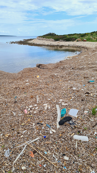 Beach pollution. Plastic bottles and other trash on the beach. Ecology, plastic garbage, environmental emergency and water. Plastic trash washed ashore.