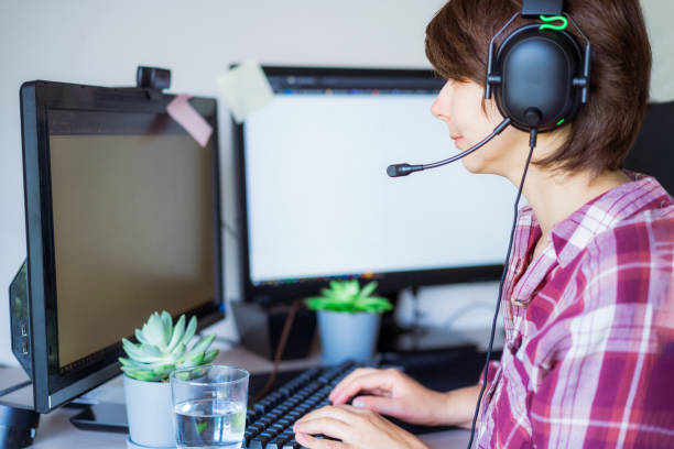 istock Mixed-race Woman in headset has video meeting or call. Customer service support representative works on a laptop. Freelance operator working in telemarketing online. Networking. Soft selective focus 1327629033