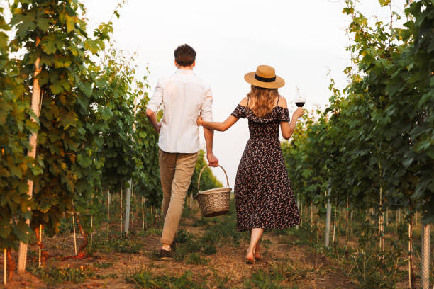 istock Loving couple outdoors drinking wine holding basket with bottles. 1327629178