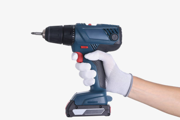 istock Master in glove holds a drill with drill on white background 1327629286