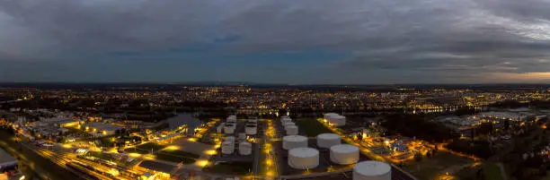 Aerial view of refinery tanks and railway station at night