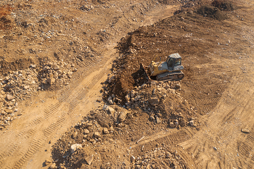 Drone view of a bulldozer is putting soil sand in the construction site