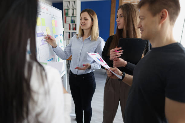 istock Young woman trainer showing information on board with graphs for listeners 1327633474