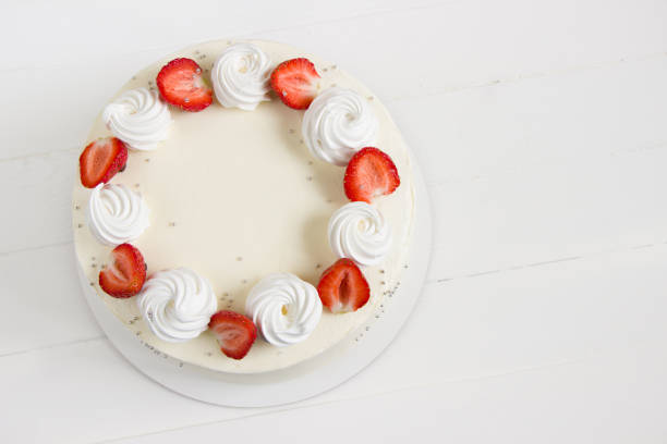 istock Beautiful white cake decoraited with meringue and fresh strawberries. White background 1327633979