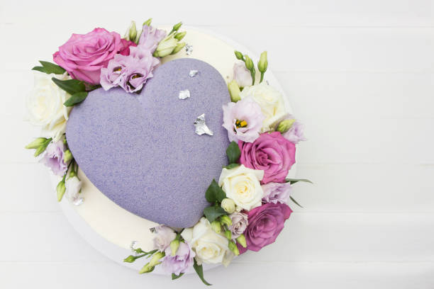 красивый свадебный торт с фиолетовым сердцем и свежими розами, белый фон - wedding reception valentines day gift heart shape стоковые фото и изображения
