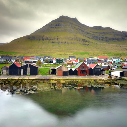 Colourfull boathouses on the shoreline of the small village of Leirvík on Faroe Islands