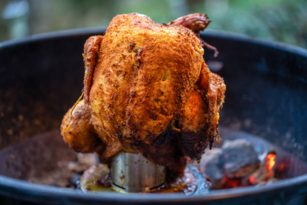 istock Marinated chicken on a chicken holder with thermometer on a barbecue with glowing charcoals. Close-up during a barbecue in the garden. 1327635800