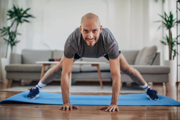 istock Man exercising on the floor at home 1327637496