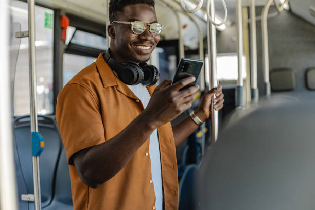 istock Young African-American man using mobile phone in public transport 1327638986