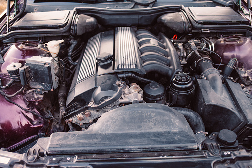 View of the engine and other details under the open hood of a car