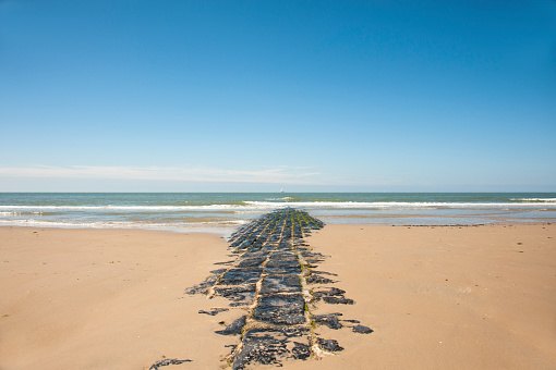 Golfbreker op het strand van de Noordzee in Belgë