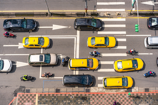 A view from directly above a street in downtown Taipei, Taiwan, with taxis, cars and people on motor scooters.