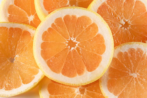 Whole and slice of orange with leaves on an isolated white background.
