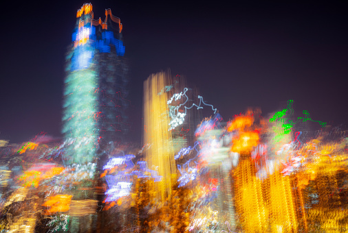 Intentional camera movement with a long exposure creating a glitchy and bizarre skyline, with the illuminated colours of the city's skyscrapers creating futuristic patterns.
