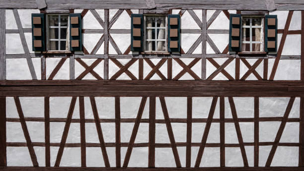 Old model building half-timbered house facade with three windows Old, partly weathered model building half-timbered house facade with three windows in close-up timber framed stock pictures, royalty-free photos & images