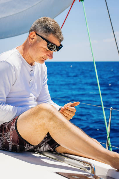 istock Businessman with smart phone on sailboat 1327651959