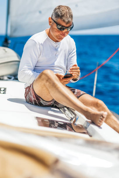 istock Businessman with smart phone on sailboat 1327652240