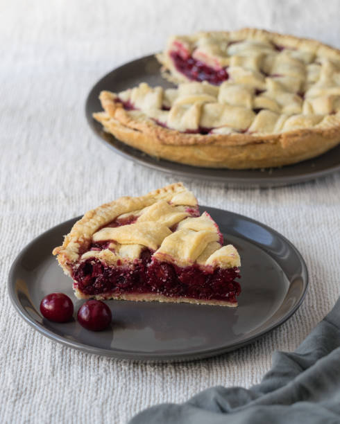 istock One piece of cherry pie cake on grey plate on light linen textile background, selective focus 1327652265