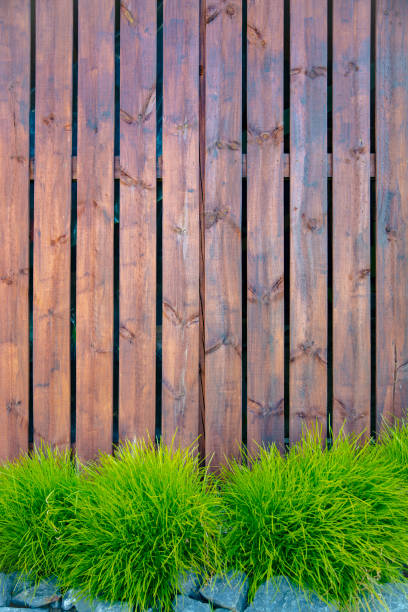 istock Fresh green grass over wood fence vertical background 1327653282