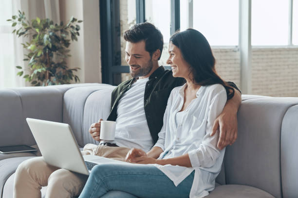 istock Beautiful young couple drinking coffee and looking on the laptop 1327653565