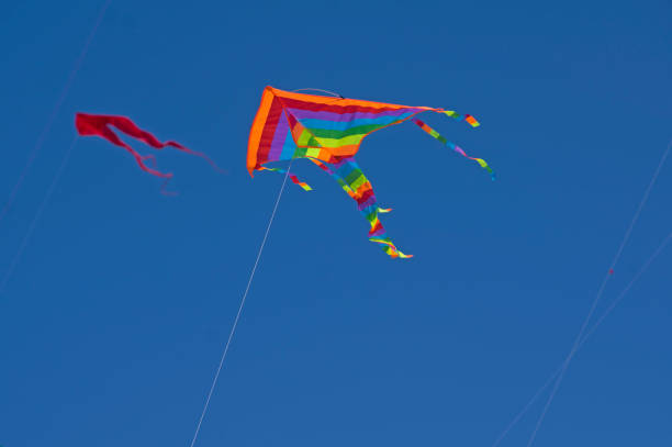 istock Isolated rainbow color kite flying in the blue sky 1327656584