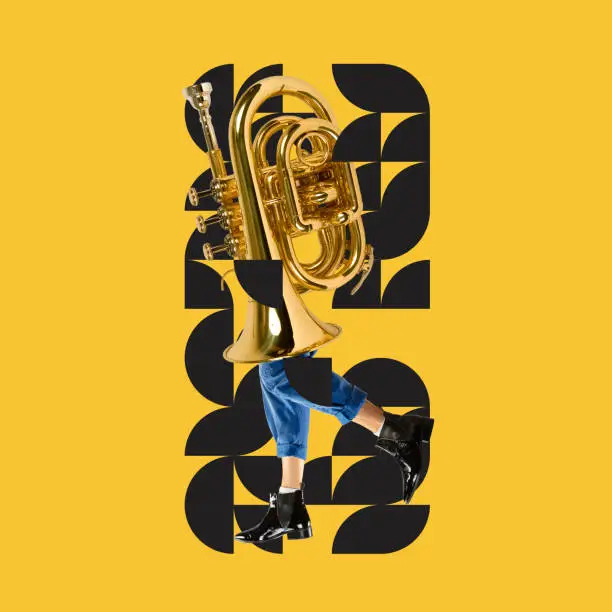 Photo of Modern art, design and music. Big golden tuba on male legs in stylish boots over yellow background with geometric pattern.