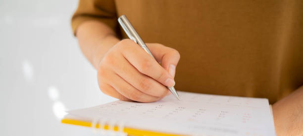 istock close up on employee man hand using finger pointing schedule (timetable) on calendar to writing list of job and make appointment meeting or manage timetable each day , life balance concept 1327662510