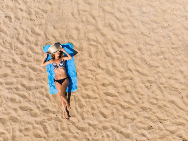 istock Woman lying on the beach 1327664554