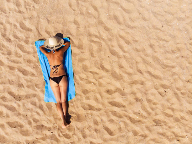istock Woman lying on the beach 1327664558