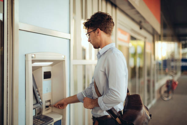 istock Man is withdrawing cash from an atm machine 1327667755