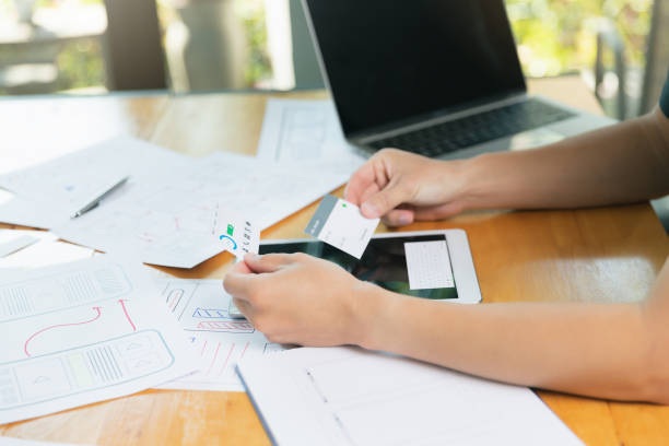 istock UX or UI designers designing on digital tablet and smartphone application layout prototype project. 1327669179