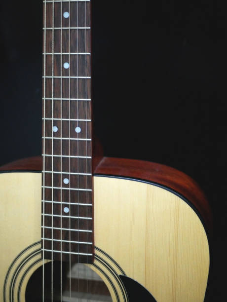 istock Acoustic guitar in black background 1327670672