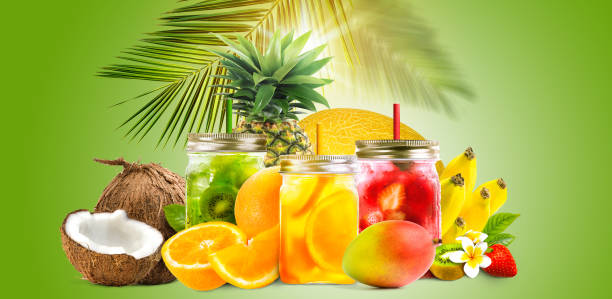 Fresh jars of juice with fruit mix on green background. Concept of tropical summer cocktails, drinks, lemonade Fresh jars of juice with Assorted tropical fruits orange, pineapple, melon, mango, kiwi, banana on green background with palm leaf. Healthy summer cocktails, drinks, lemonade with copy space juice bar stock pictures, royalty-free photos & images