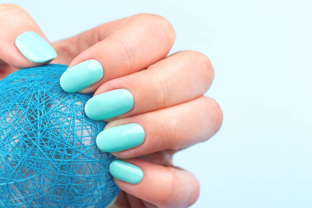 istock Hand with turquoise nails with ball 1327674407