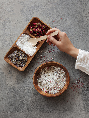 Woman making homemade bath salt with rose and lavender