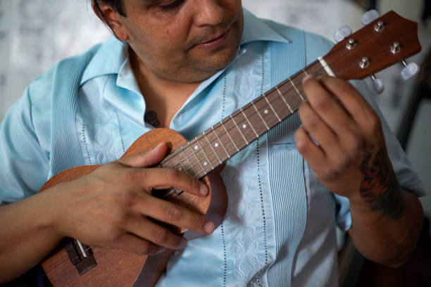 istock Latino man teaching to play ukulele online 1327676540