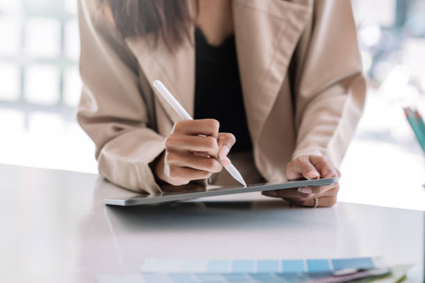 istock Businesswoman using a pen to taking notes on digital tablet at office. 1327677819
