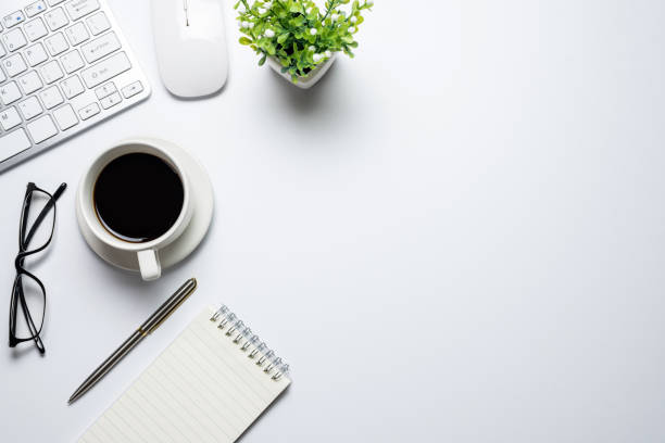 istock Top view of the desk with keyboard coffee notebook mouse placed on the desk white copy space flat paste. 1327677922
