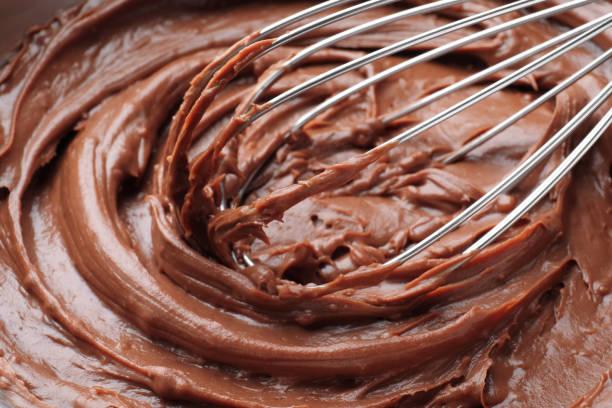 istock Whipping chocolate cream with balloon whisk, closeup view 1327678822