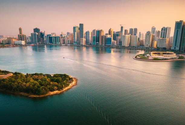 Emirate of Sharjah cityscape waterfront rising above Al Noor Island at city downtown in the UAE Emirate of Sharjah cityscape waterfront rising above Al Noor Island at city downtown in the United Arab Emirates dubai island stock pictures, royalty-free photos & images