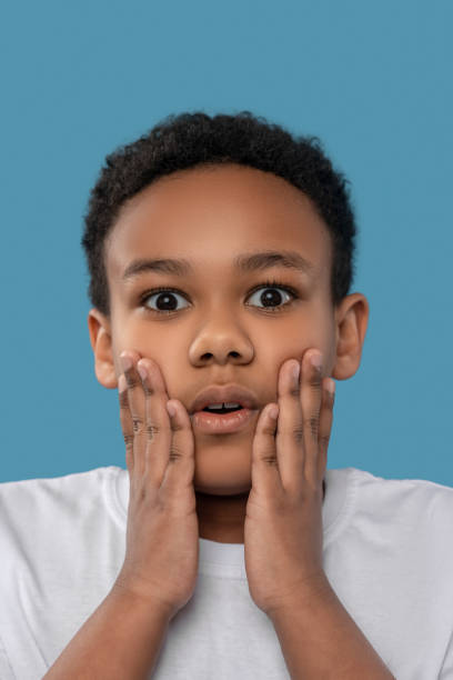istock Shocked boy touching his cheeks with his palms 1327679912