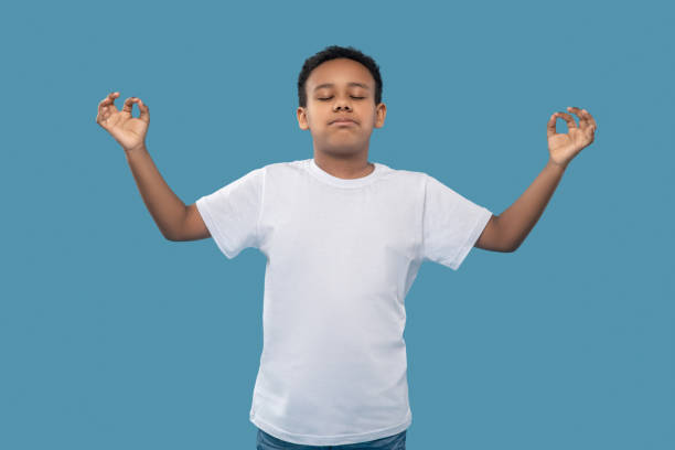 istock Boy with closed eyes and hands to sides 1327679971