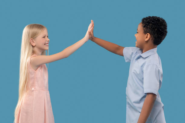 istock Boy and girl with outstretched hand touching palms 1327679993