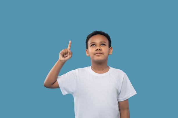 istock African american boy raising hand pointing up 1327680023