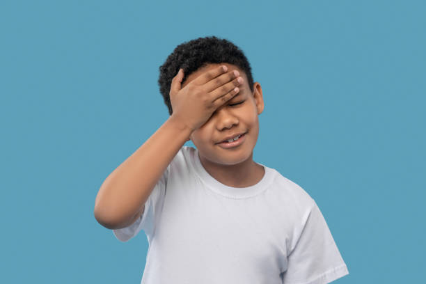 istock Unhappy boy touching his forehead with hand 1327680044
