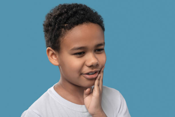 istock Suffering face of dark skinned boy with toothache 1327680046